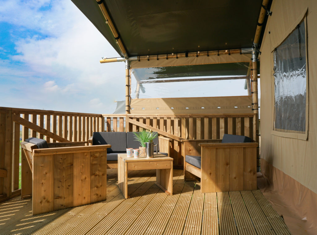Photo of outdoor decking on safari tents with relaxed outdoor seating.